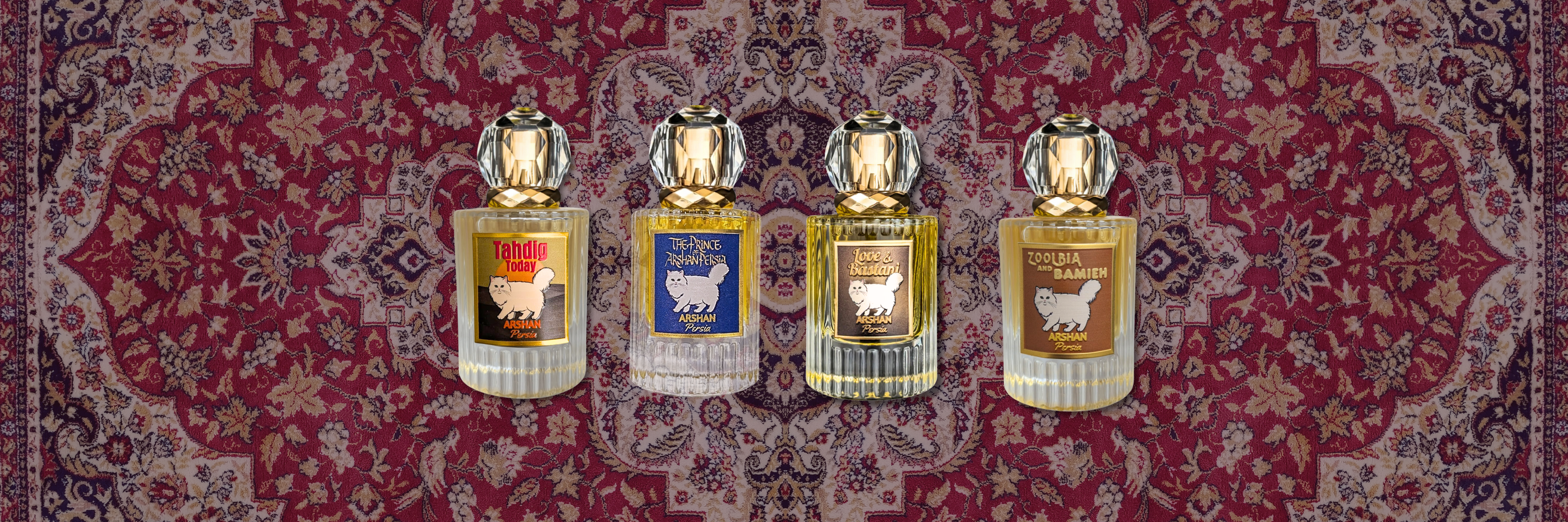 Four clear ribbed glass perfume bottles with large, faceted clear crystal caps and gold necks, arranged horizontally against the background of an intricate red, cream, and purp Persian rug pattern. Each bottle features a label with a gold border and an illustration of a fluffy white Persian cat. From left to right, the labels read: 'Tahdig Today', 'The Prince of Arshan Persia', 'Love & Bastani', and 'Zoolbia and Bamieh' All labels feature the sub-text 'Arshan Persia' below the Persian cat.